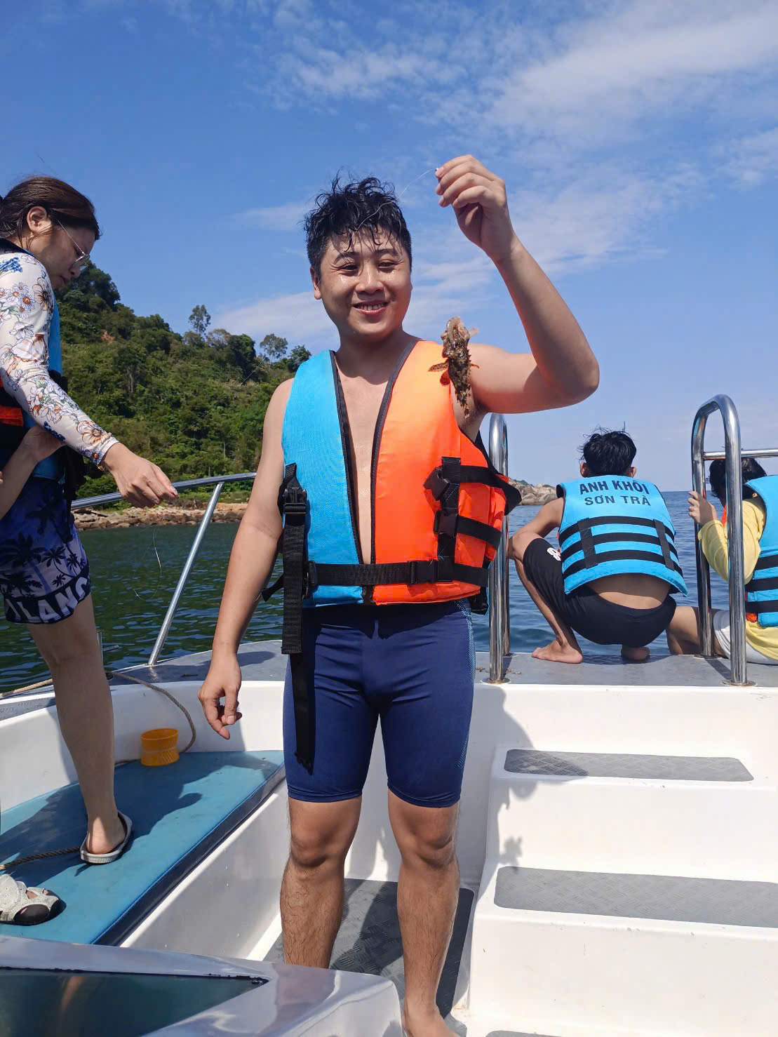 직접 잡은 물고기를 들어 올리며 활짝 웃는 관광객
