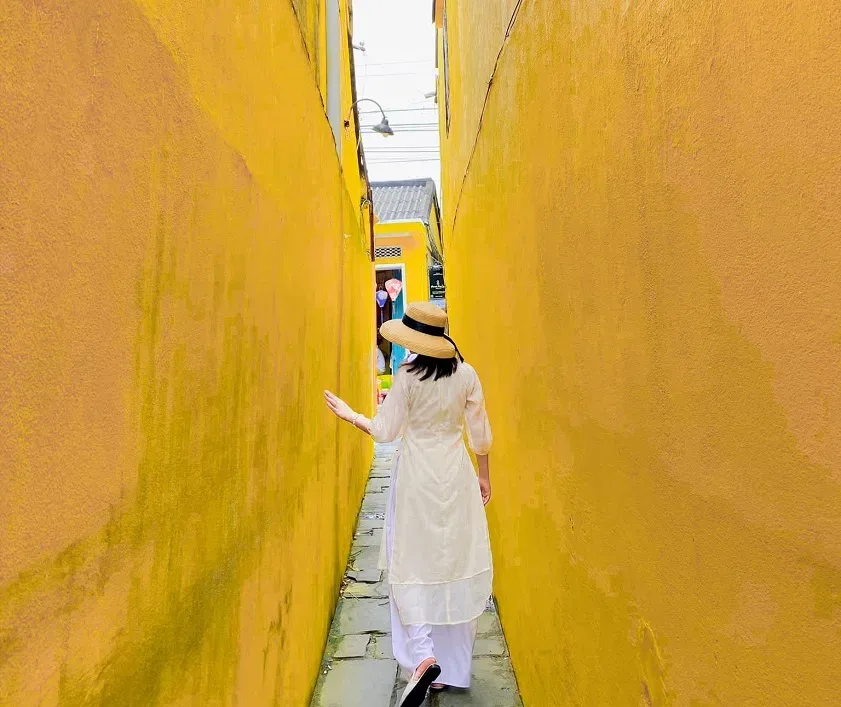 best photo spots in Hoi An narrow mossy yellow alleyway portrait